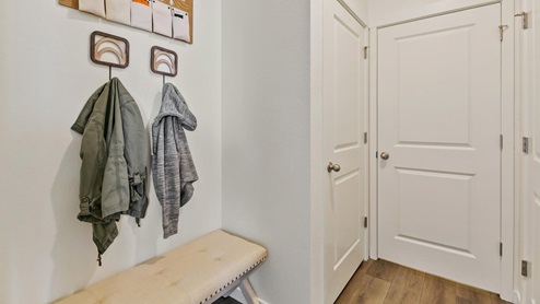 mud room with coat hooks and sitting area