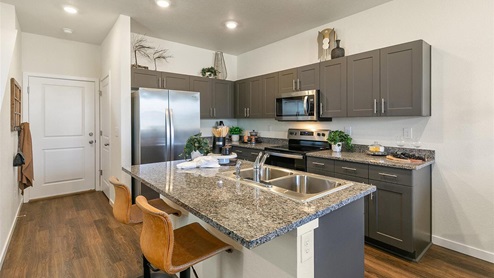 staged gray cabinet kitchen with stainless steel appliances