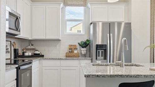 staged white kitchen with stainless steel appliances