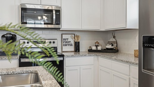 staged white cabinet kitchen with stainless steel appliances