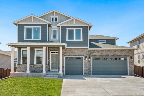 Exterior image of two-story Timberleaf home with ledgerstone façade, wide driveway, and three car garage, by D.R. Horton in Thornton, Colorado