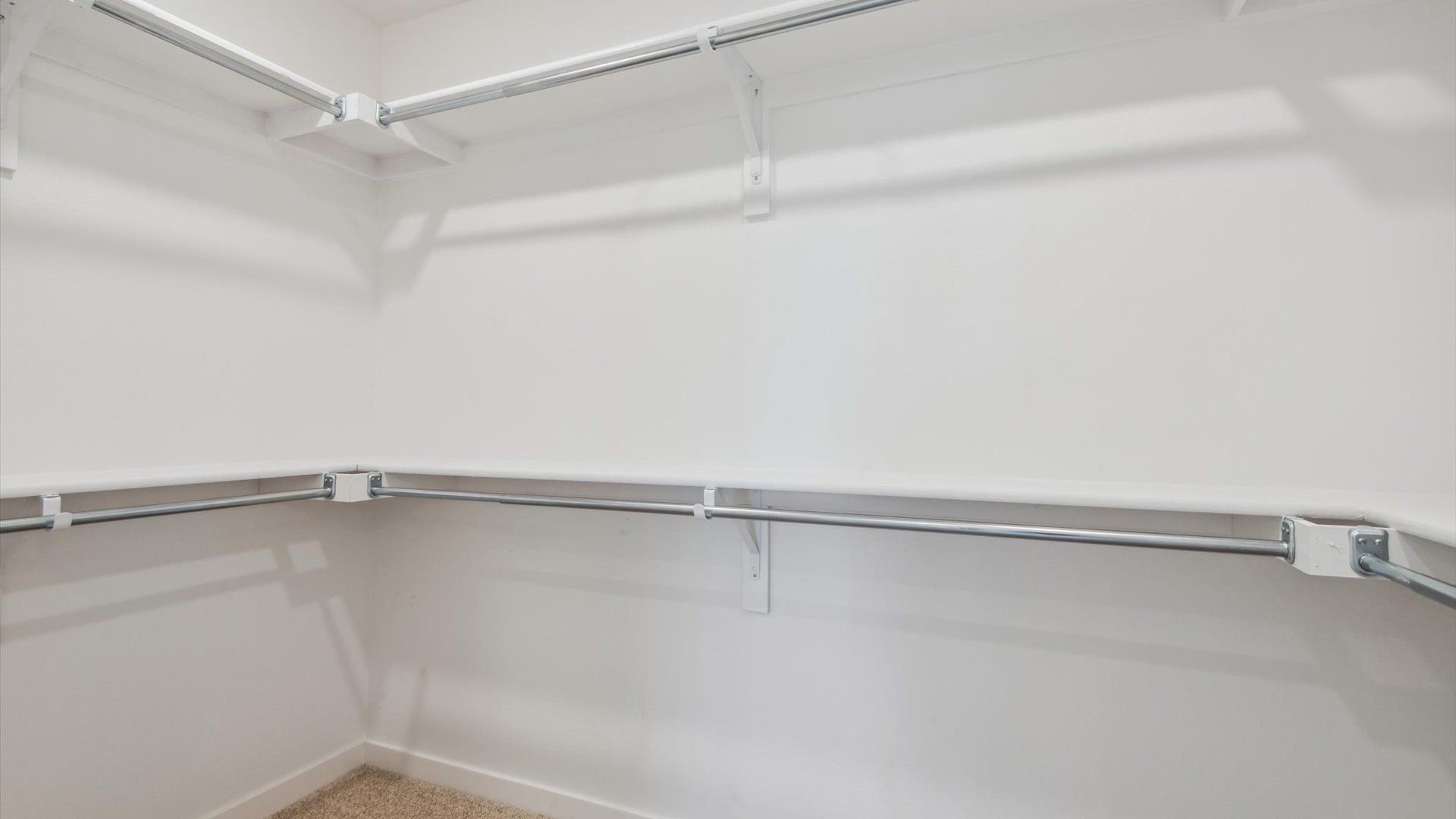 Private bedroom ensuite in the Douglas home design features a spacious walk-in closet with built-in shelving and rods