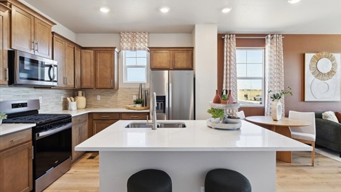 Open-concept kitchen with stainless steel appliances in Horizon Uptown home