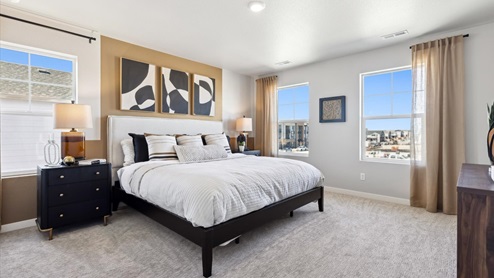 Primary bedroom in furnished model home at Horizon Uptown new home community by D.R. Horton