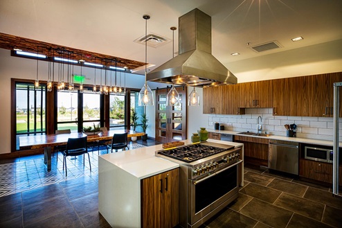 Stainless steel appliances such as six burner gas stove featured in community kitchen at Harmony by D.R. Horton