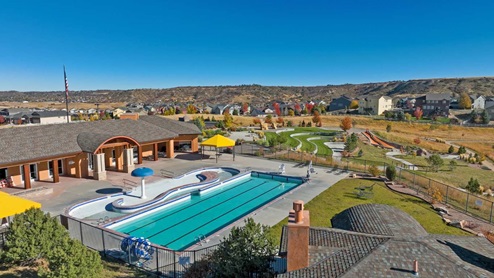 Neighborhood amenities at Crystal Valley with community pool and splash pad in foreground, and park facilities and playfields