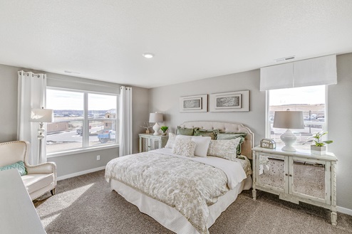 Henley model home at Pine Ridge at Crystal Valley primary bedroom with multiple large operable windows and plush carpeting