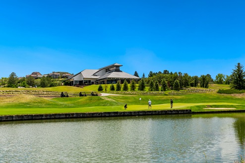 Plum Creek Golf and Country Club located in Castle Rock Colorado, with pond, golf carts and golfers playing in foreground