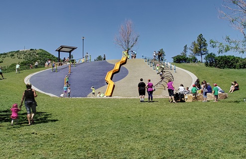 40-foot long yellow slide on a hillside in the Adventure Playground of Philip S. Miller Park located in Castle Rock Colorado