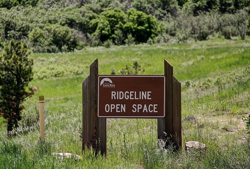 Wooden monument sign for the Ridgeline Open Space, a 9-mile loop hiking and biking trail located in Castle Rock Colorado