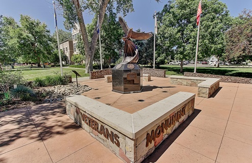Veterans monument sign at corner of 4th and Wilcox St. in downtown Castle Rock with bronze eagle statue, flags and seating