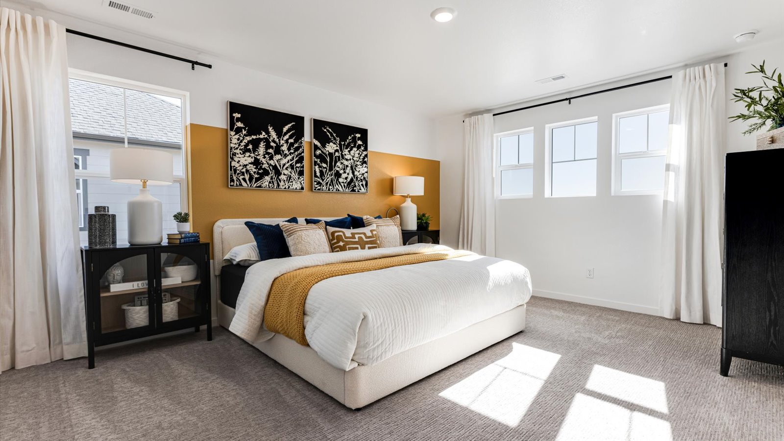 Primary bedroom with large windows in new home in Watkins Colorado