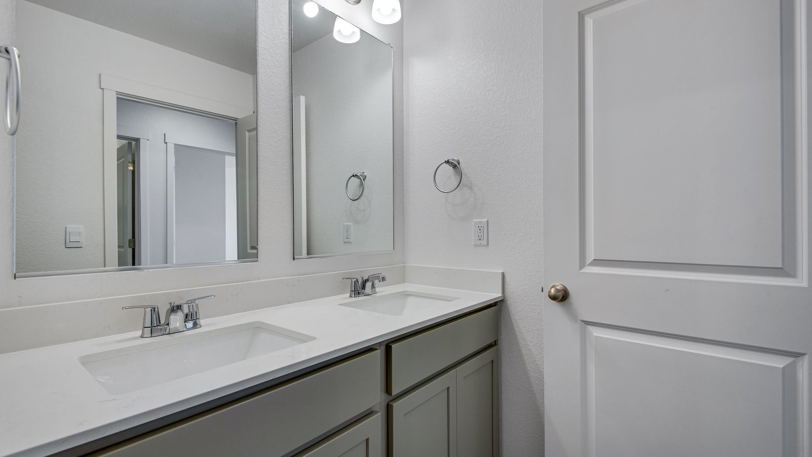 Secondary bathroom with dual vanity sinks in new home at Sky Ranch Community