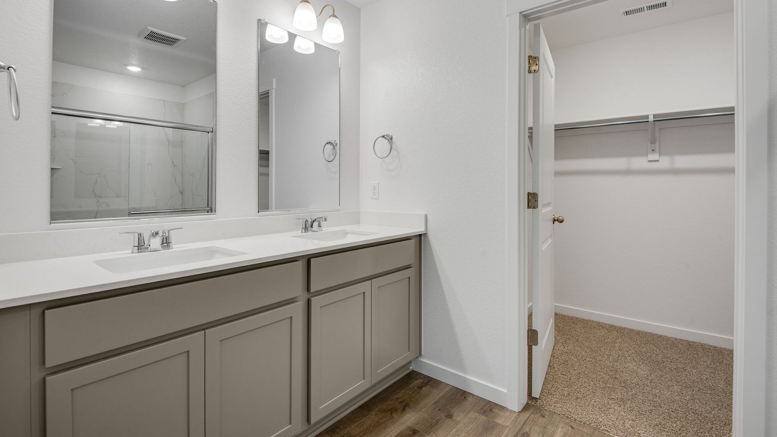 Primary attached bathroom with dual vanity sinks in new home community in Denver Colorado