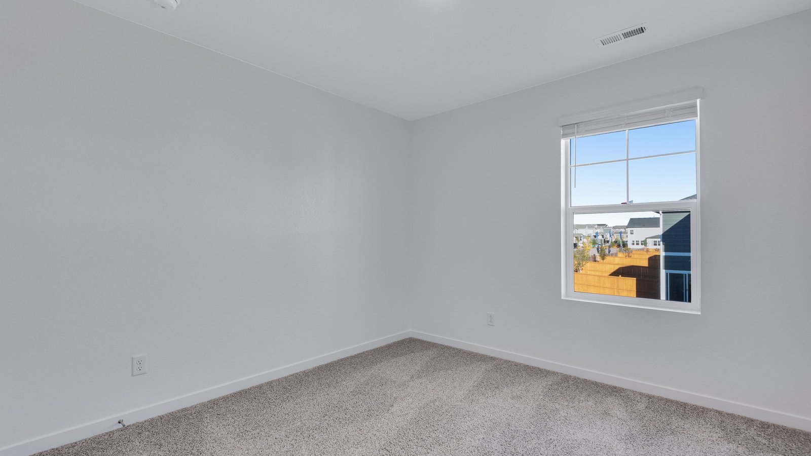 Secondary bedroom with large window in new home at Sky Ranch