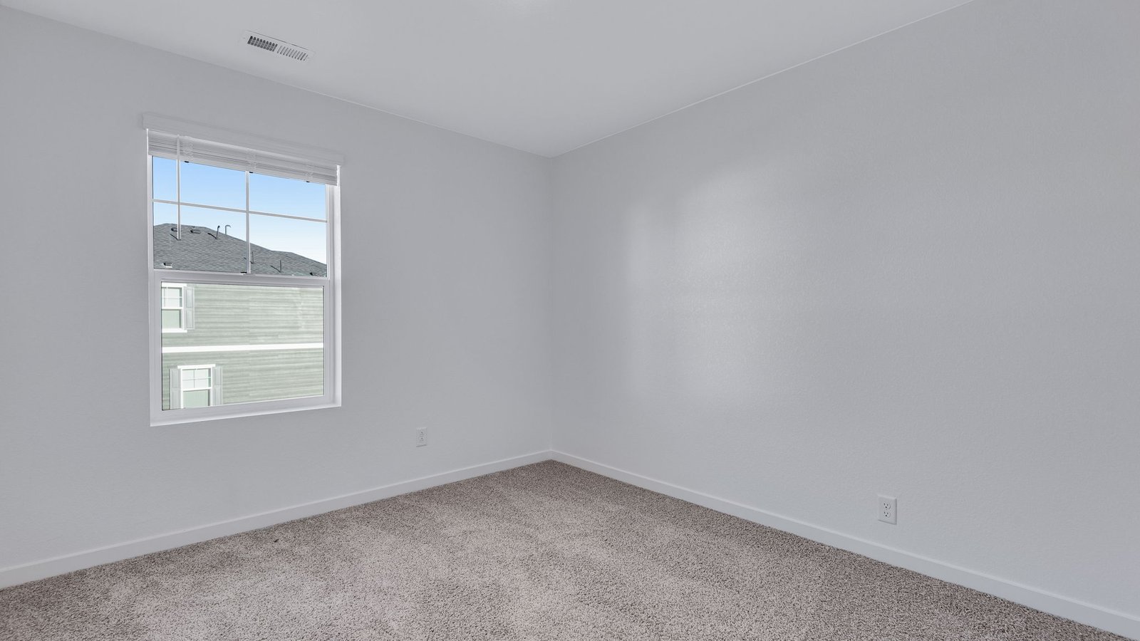 Secondary bedroom with large window in new home at Sky Ranch