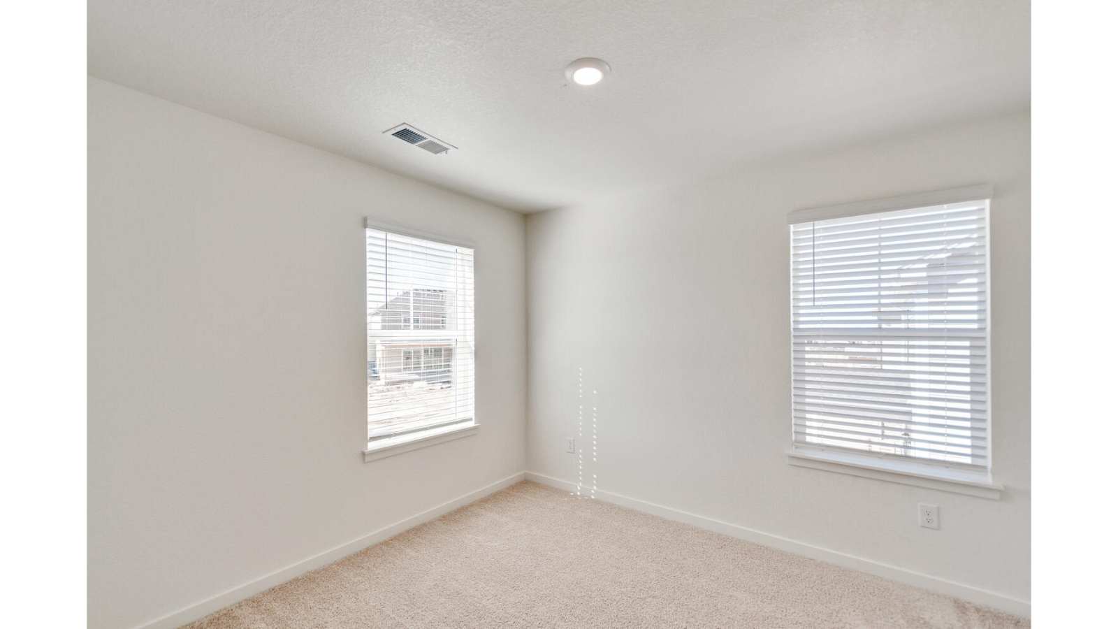 Secondary bedroom with large windows in new Watkins, Colorado home
