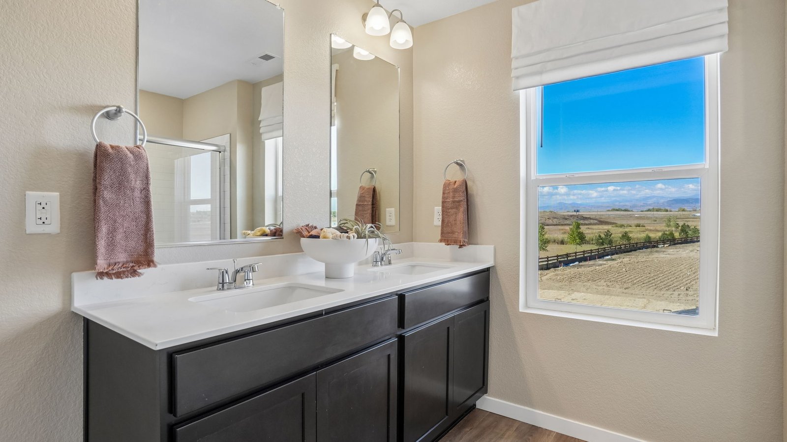 Attached private primary bathroom with dual vanity sinks in new home in Monument, Colorado
