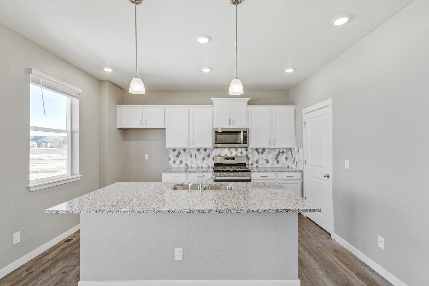 Alternate view of kitchen with white cabinetry