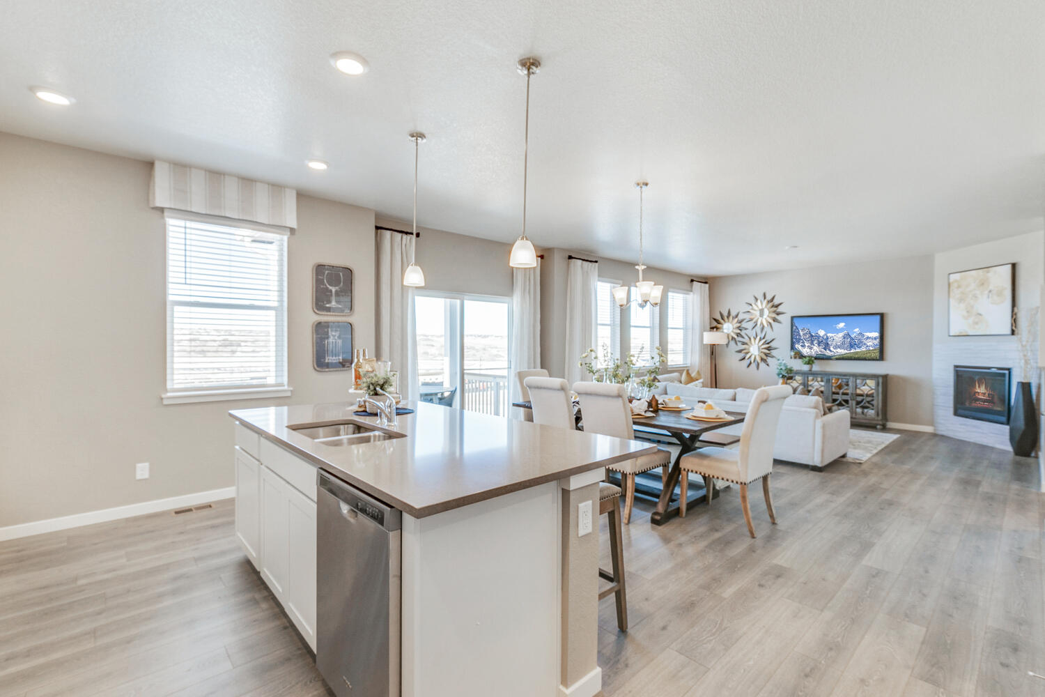 Kitchen island with dishwasher, sink and electrical outlets overlooking dining and great room