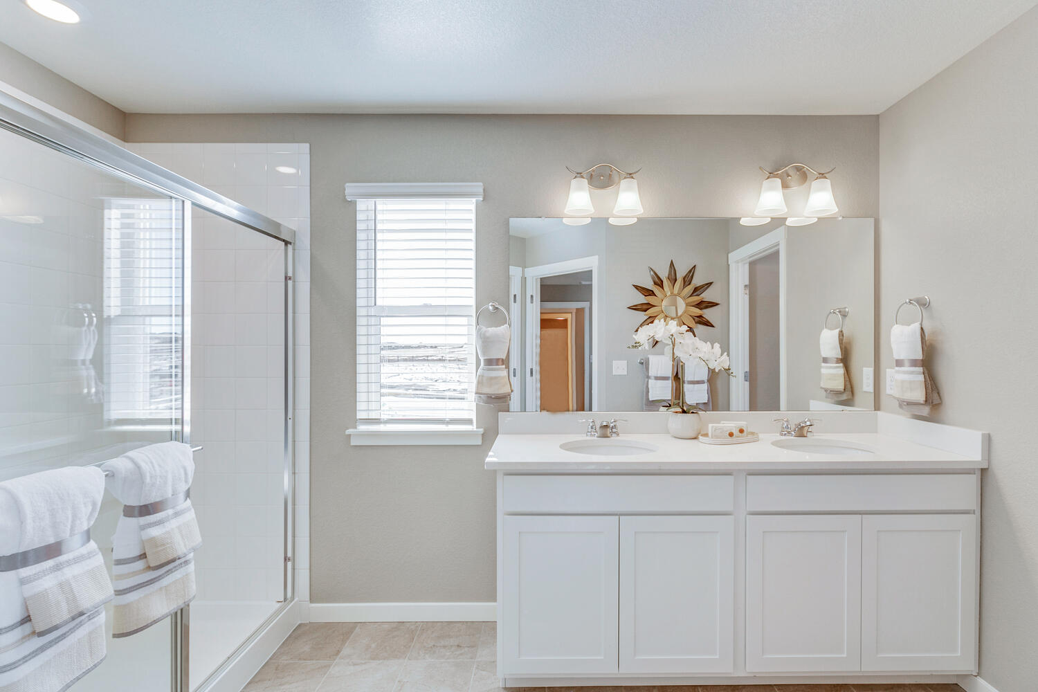 Private bathroom with step-in shower, window and double vanity