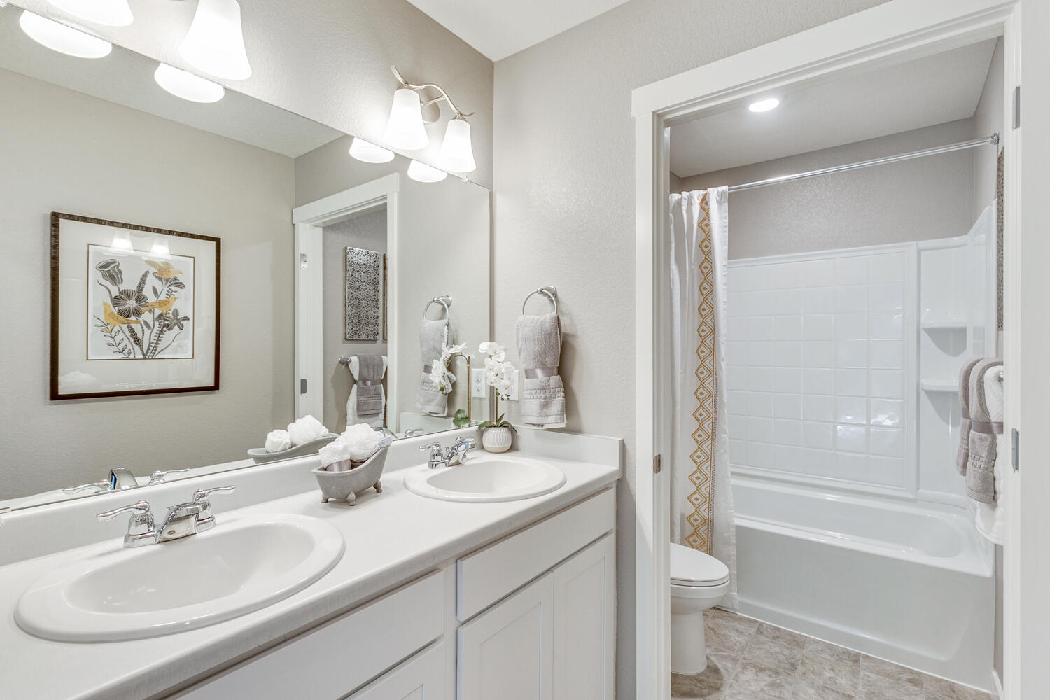 Split bathroom with tub-shower combo and dual-sink vanity
