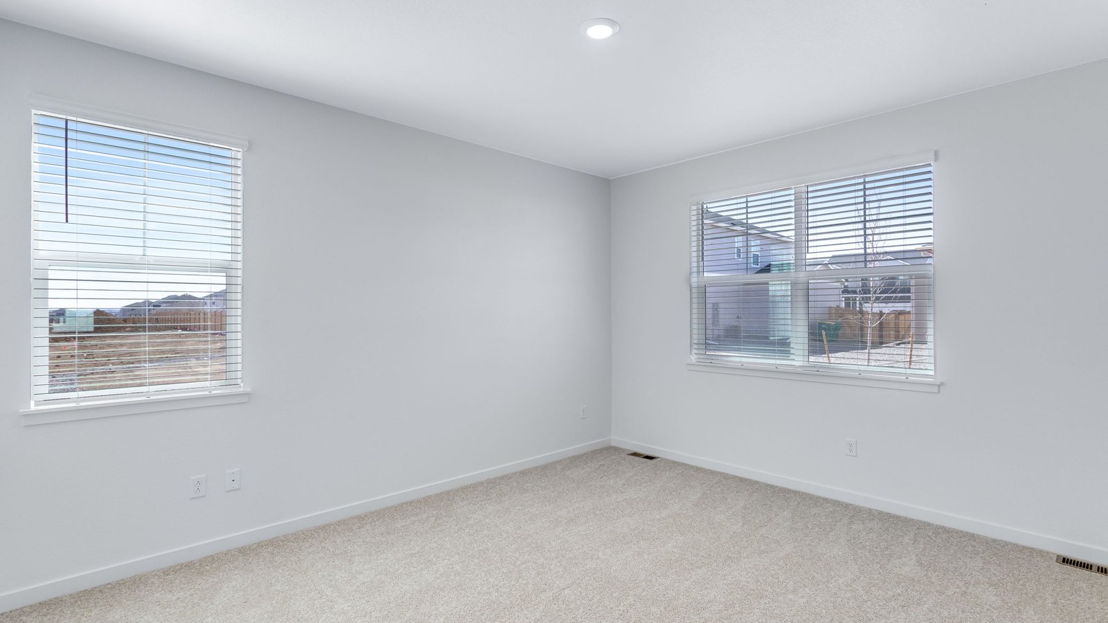 Secondary bedroom with large windows in new home community Trails at Crowfoot