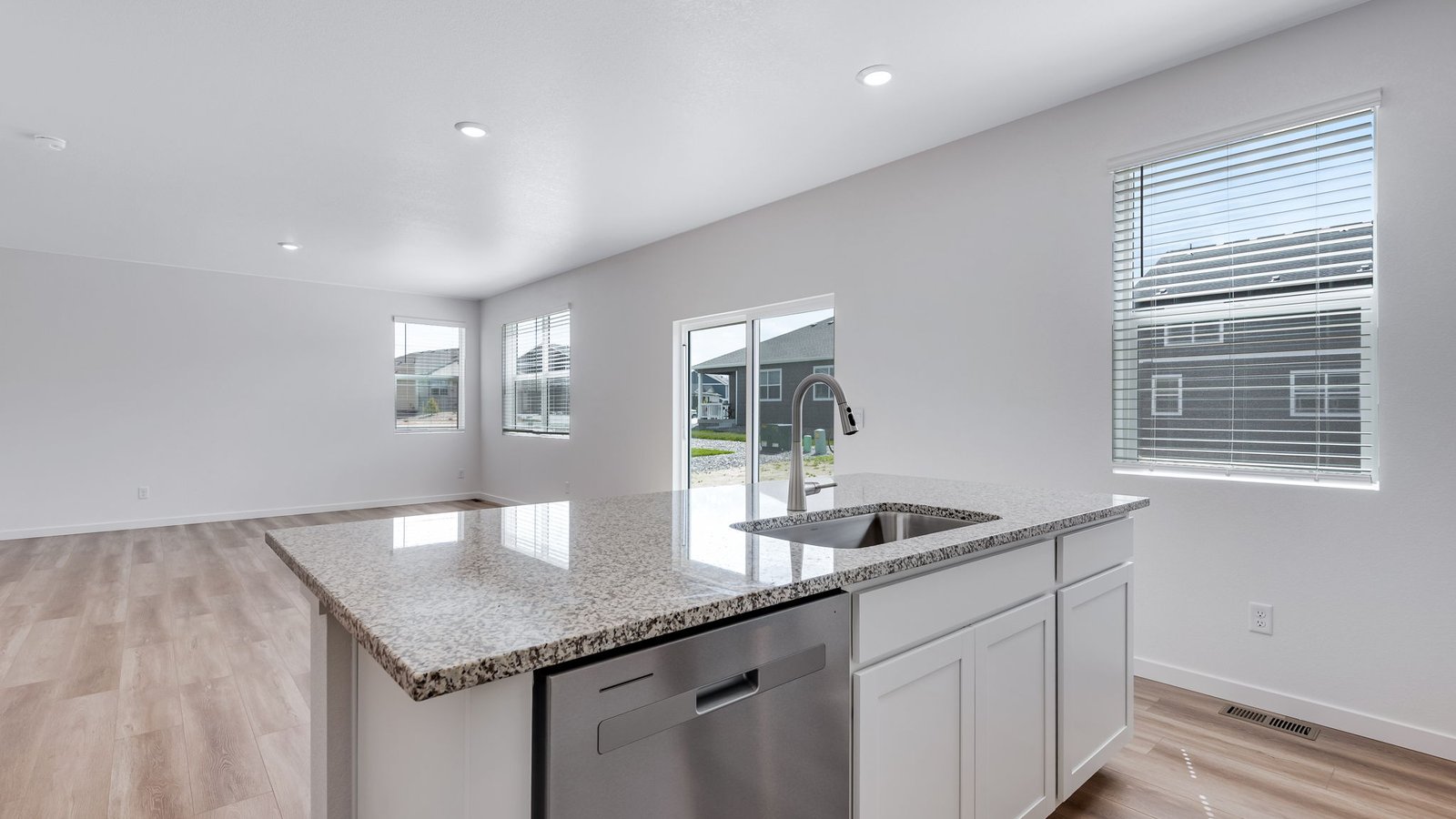 Spacious great room with open-concept design flowing into kitchen and dining area.
