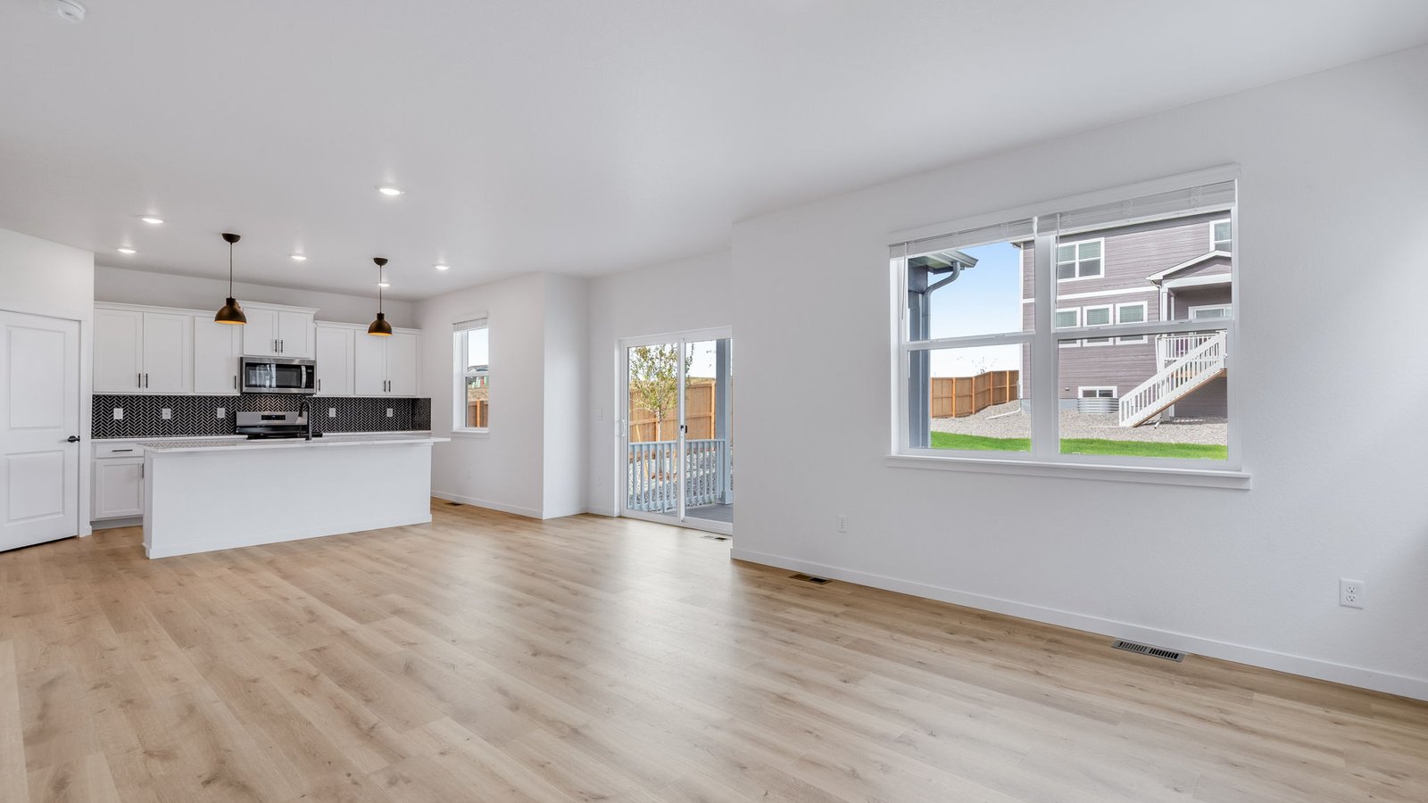Spacious living room with large windows in new home in Parker Colorado