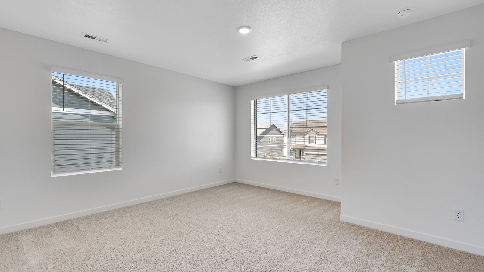 Spacious primary bedroom with large windows and private ensuite bathroom.