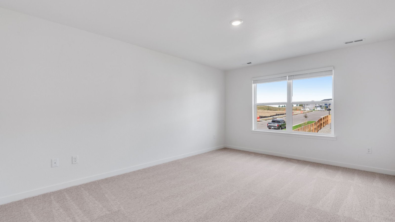 Spacious primary bedroom with large window in new home in Parker Colorado
