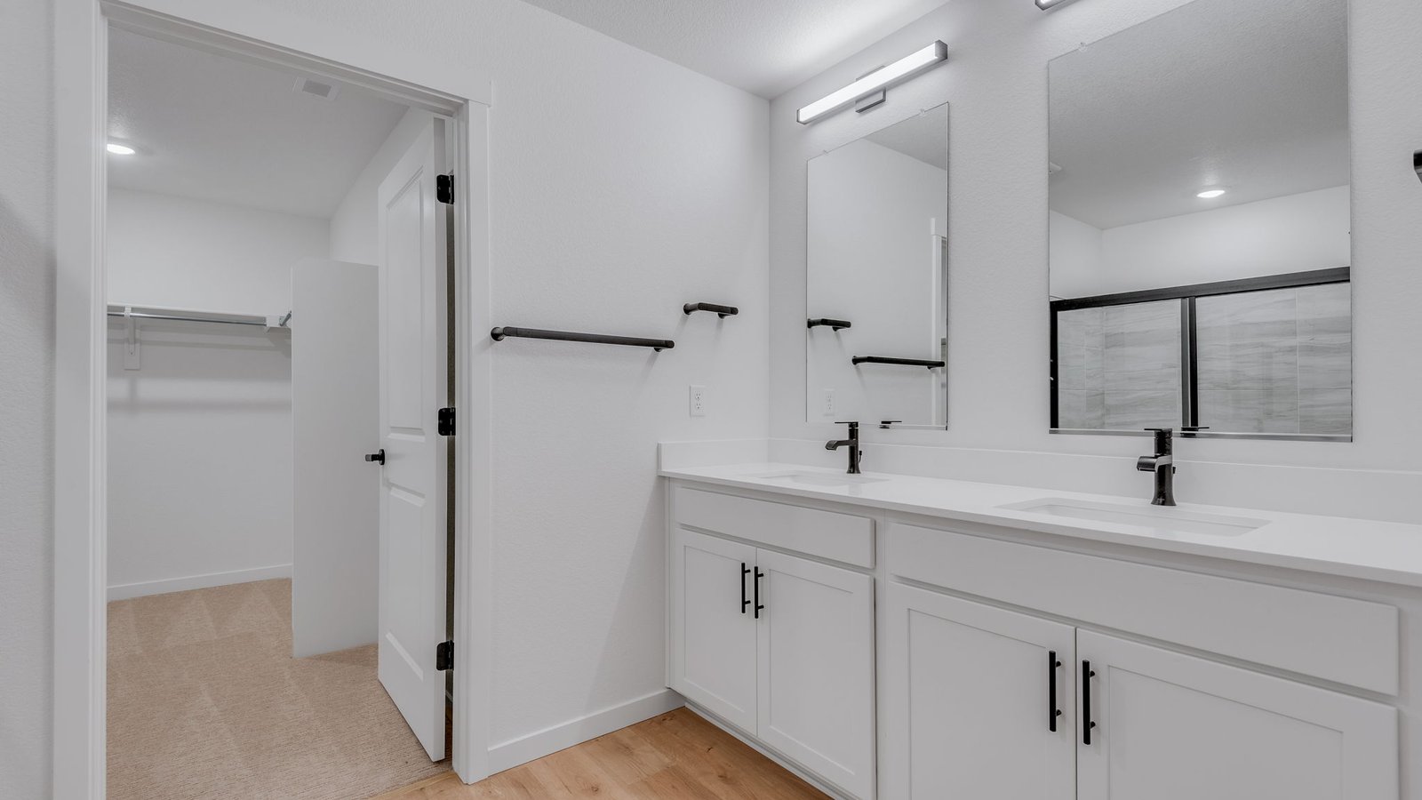 Attached private primary bathroom with dual vanity sinks in new home in Parker Colorado