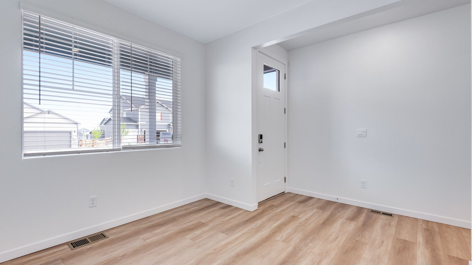 Welcoming foyer with natural light and access to study, powder bath, and main living areas in Holcombe home.