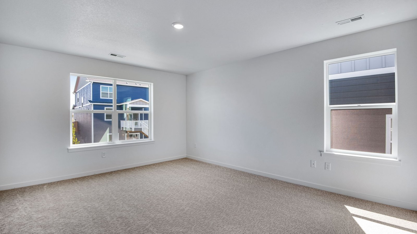 Spacious primary bedroom with large windows in luxurious new neighborhood Trails at Crowfoot