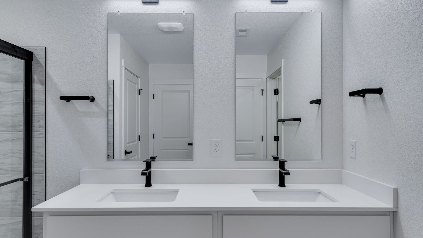 Attached private primary bathroom with dual vanity sinks