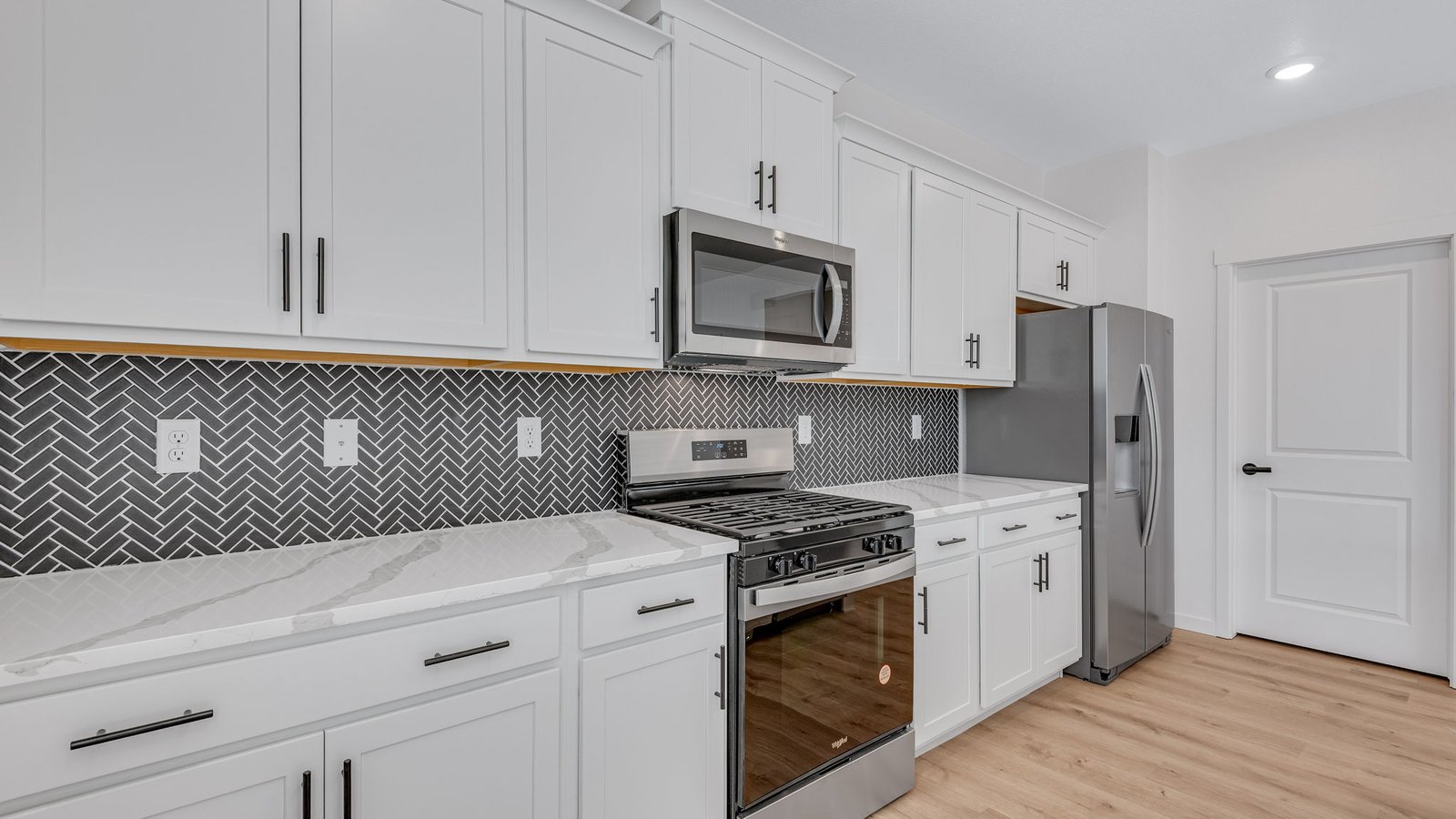 Stylish kitchen with white cabinetry, functional layout, and open sightlines to living area