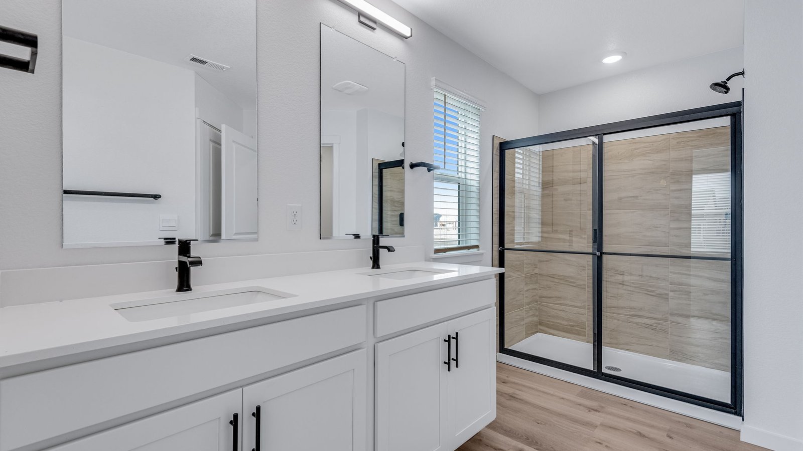 Owner’s bath featuring spacious vanity and contemporary finishes.