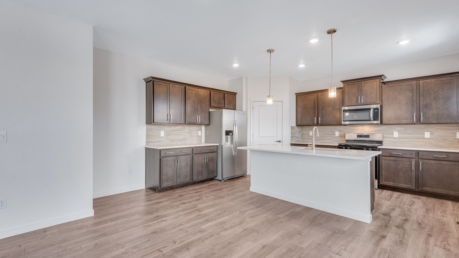 Modern kitchen with quartz countertops, brown cabinets, and ample prep space