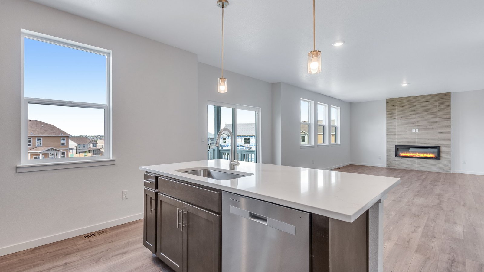 Open kitchen featuring warm brown cabinetry paired with sleek quartz countertops