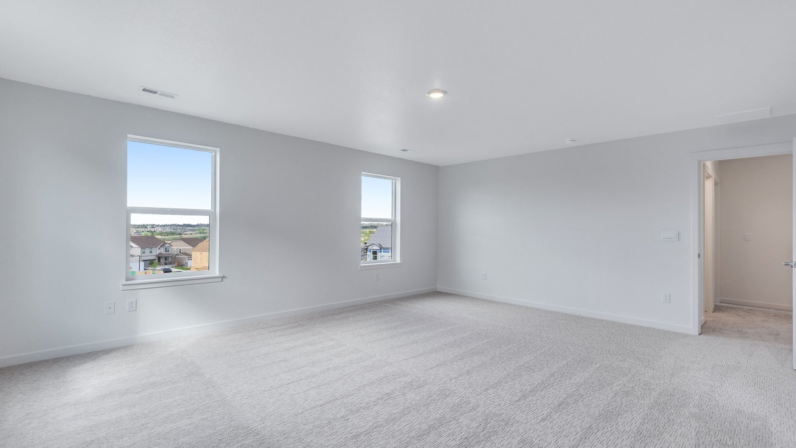 Spacious owner’s suite with large windows and neutral finishes