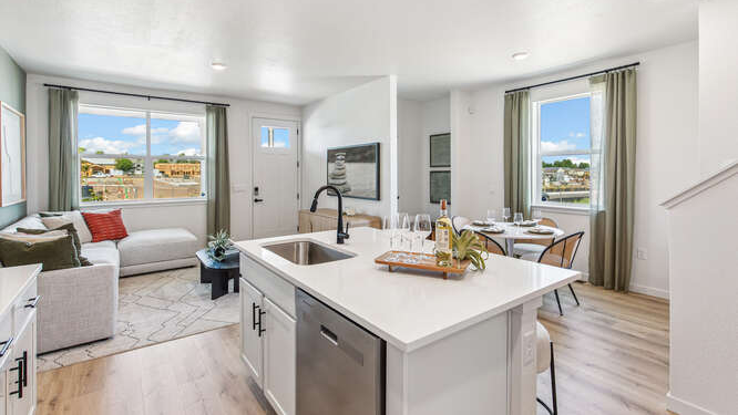 Melbourne model wide angle view of kitchen, great room and dining of furnished model home displaying contemporary LED light fixtures