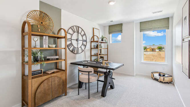 Melbourne model home at Arcadia secondary bedroom furnished as a home office featuring a large window and clerestory window