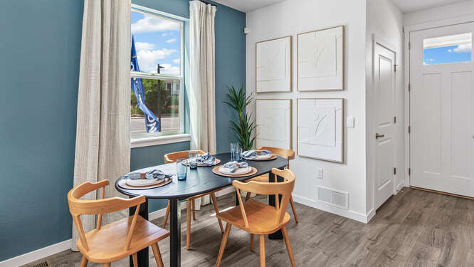 Furnished model home dining room with tall singular operational window, with nearby powder room accessible at left