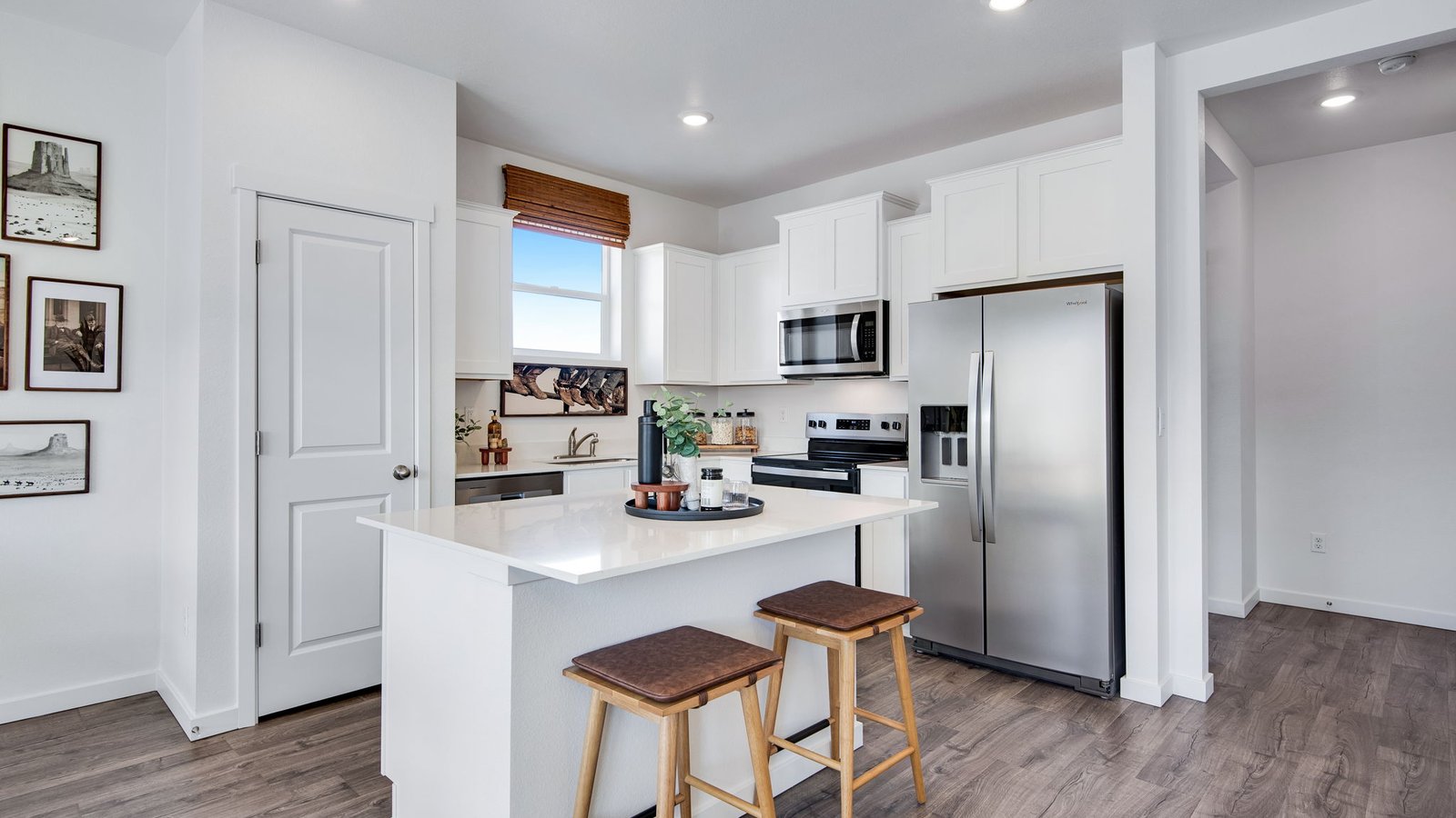 Contemporary kitchen in the Osprey floor plan with a spacious island, quartz countertops, stainless steel appliances, and modern cabinetry.