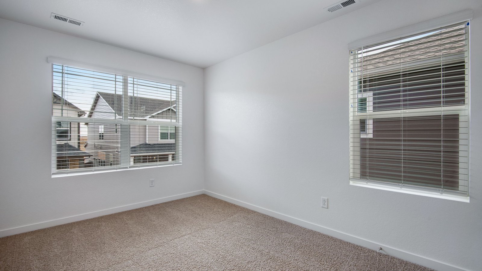 Secondary bedroom with large windows in new home in Commerce City Colorado