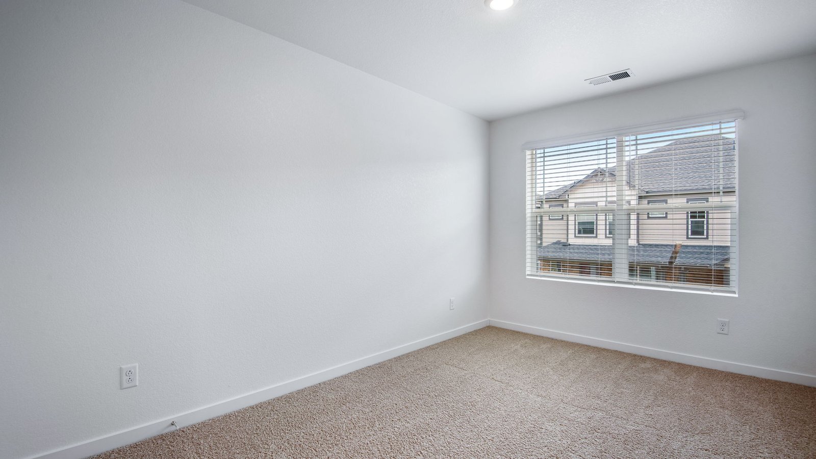 Secondary bedroom with large windows in new home community Settler's Crossing by D.R. Horton