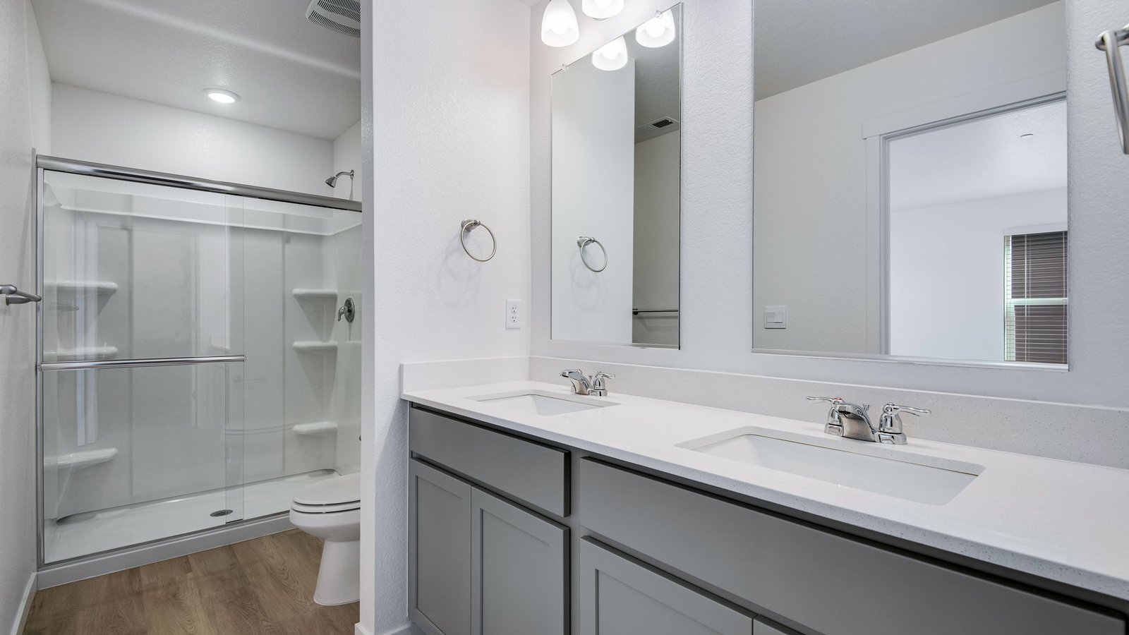 Attached private primary bathroom with dual vanity sinks in new home community Settler's Crossing