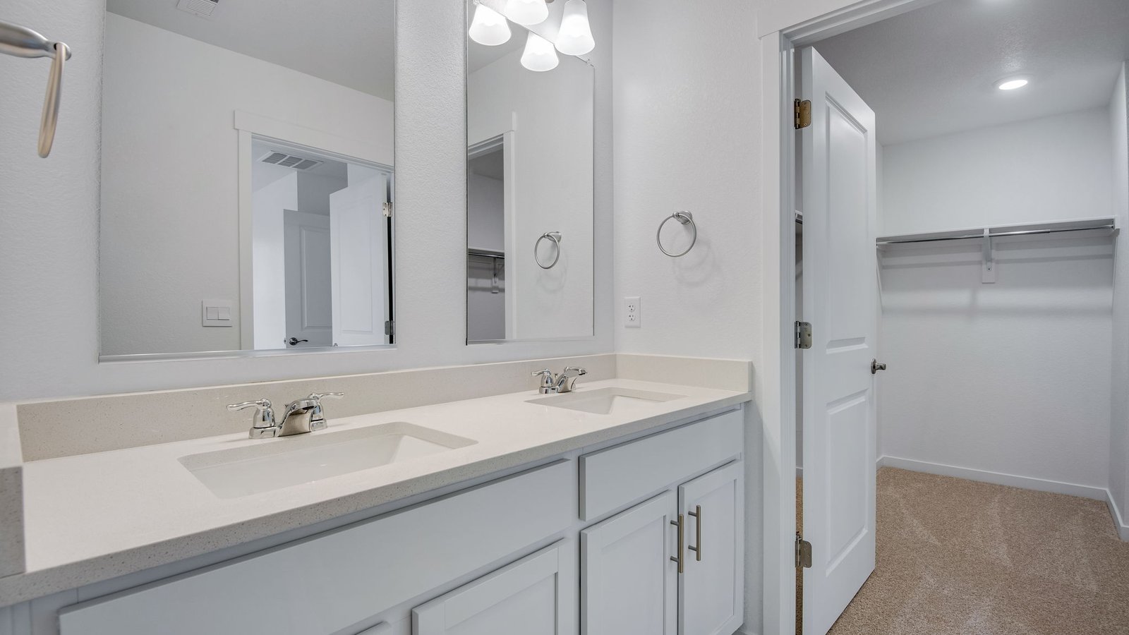Attached private primary bathroom with dual vanity sink in new home in Commerce City Colorado