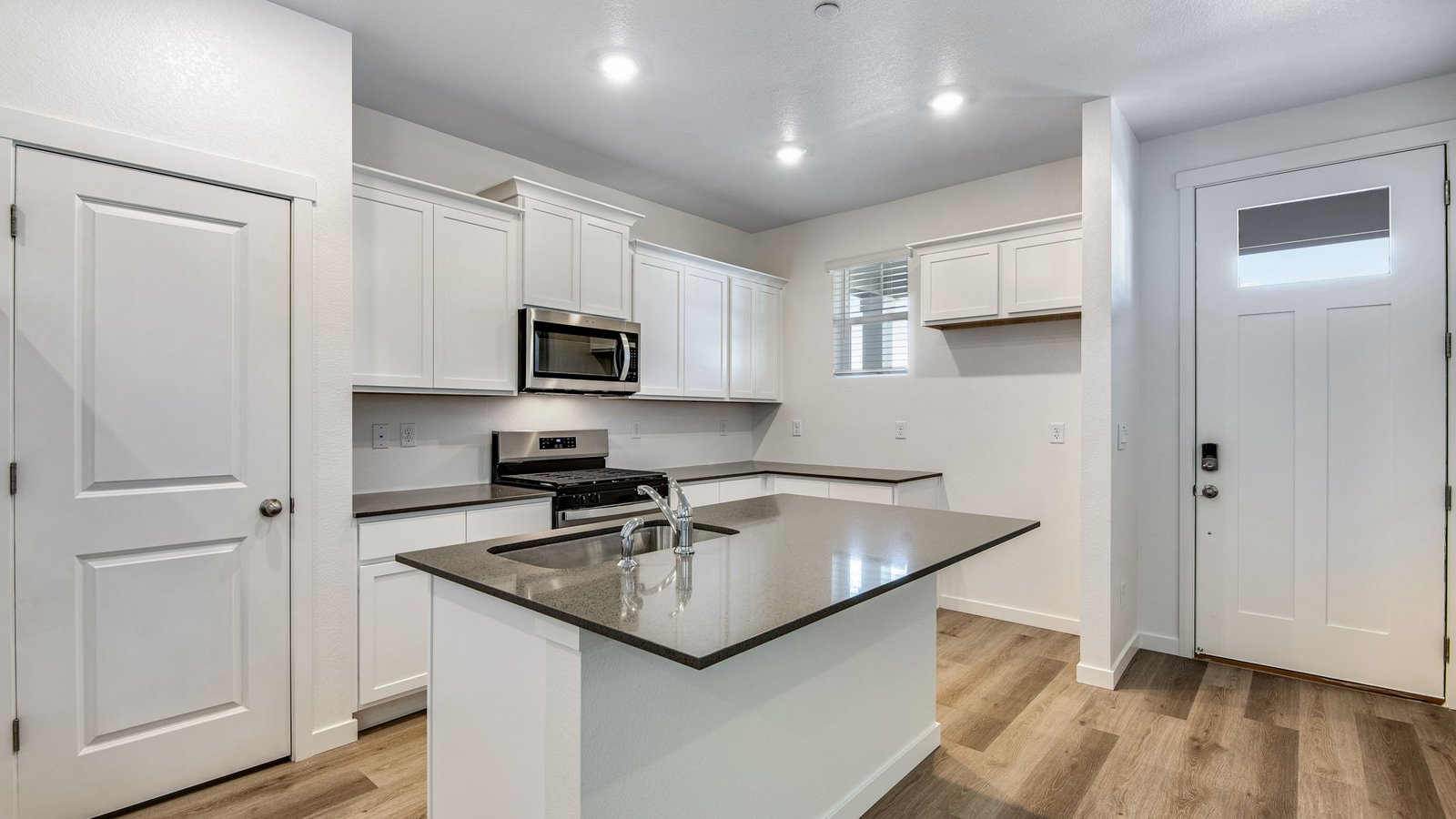 Open-concept kitchen with white cabinetry and spacious layout in the Muirfield home at Settlers Crossing.