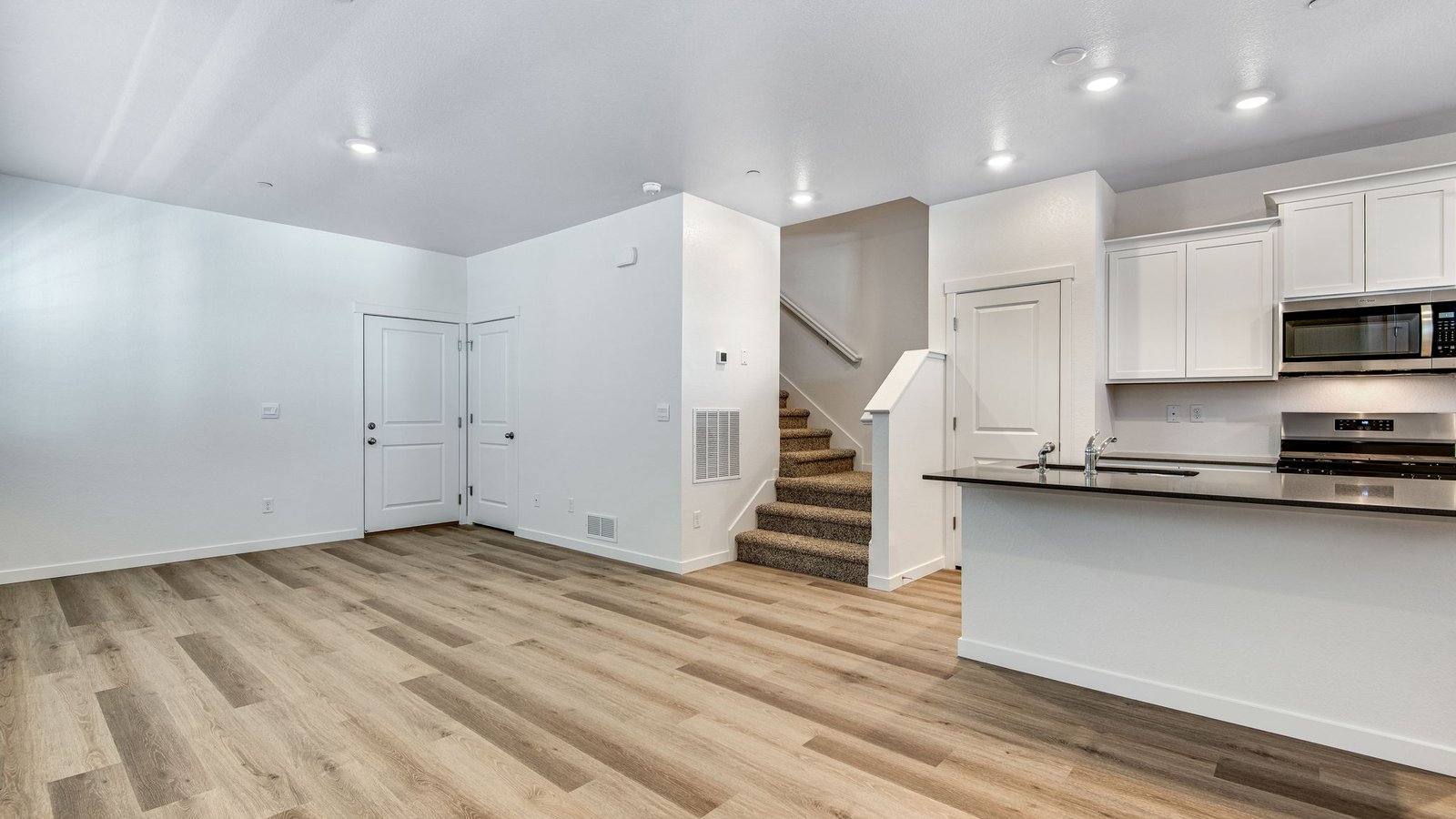 Light-filled kitchen design with white cabinets and clean finishes in a Settlers Crossing Muirfield home.